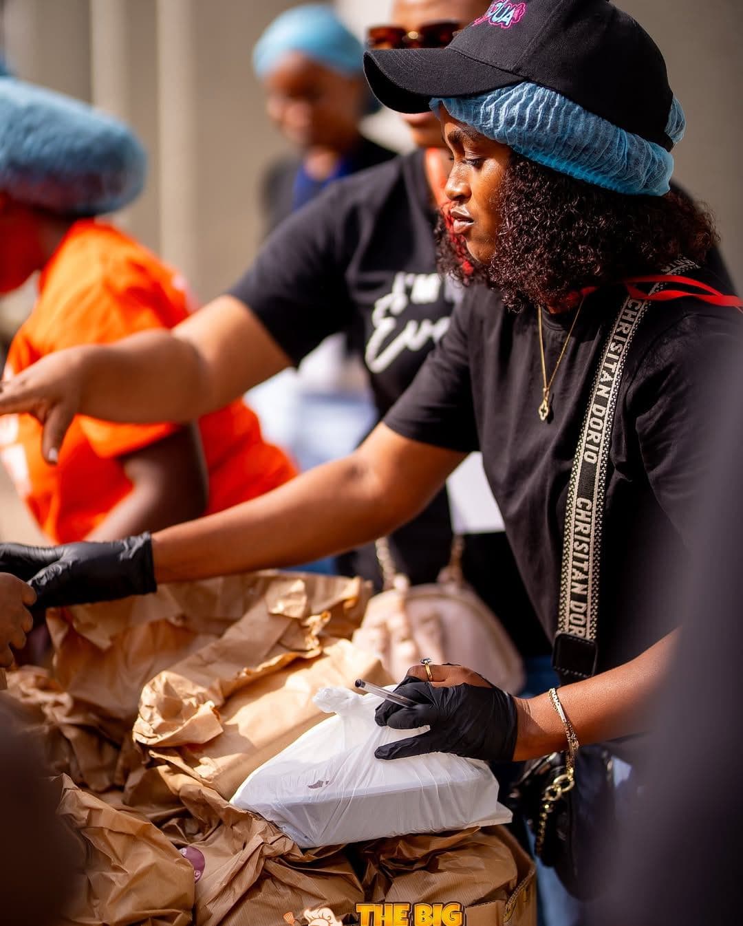 Volunteers in hairnets packing food packs