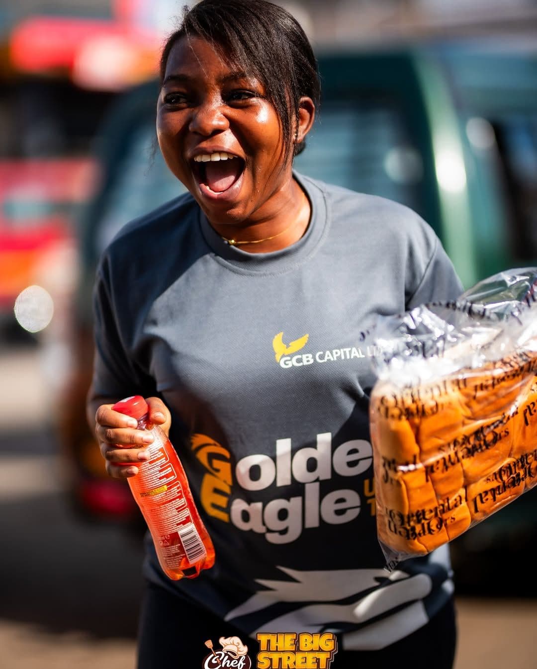 A delighted guest holding bread and a drink