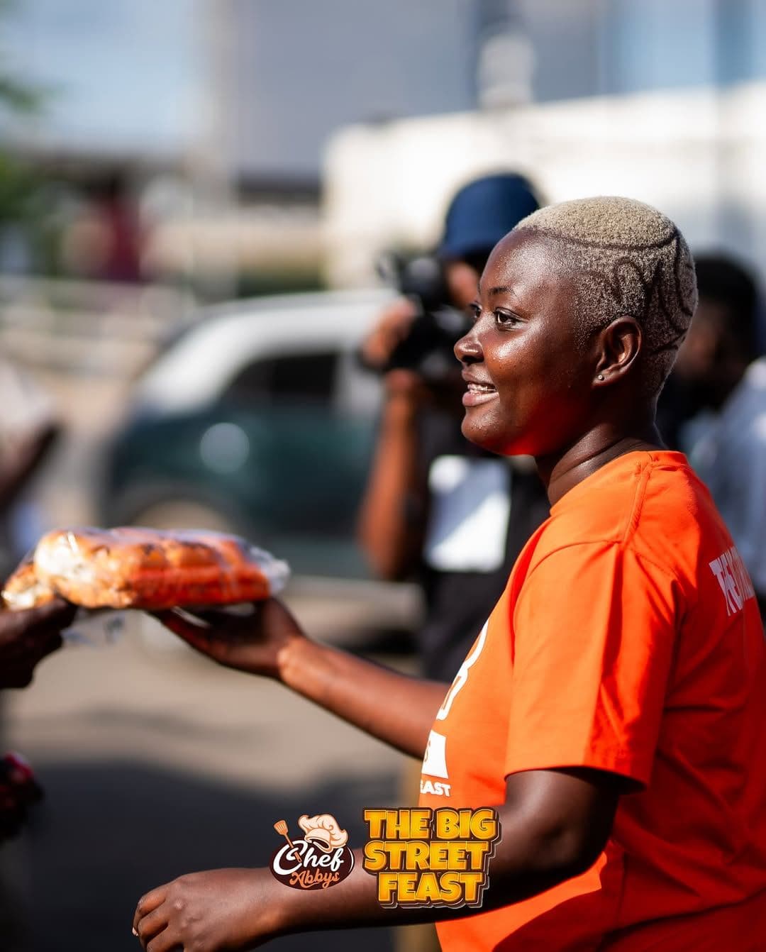 A volunteer serving a food pack on the street